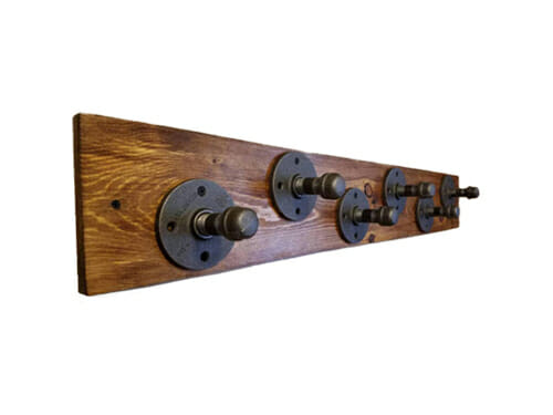 industrial pipe coat hooks on wooden board