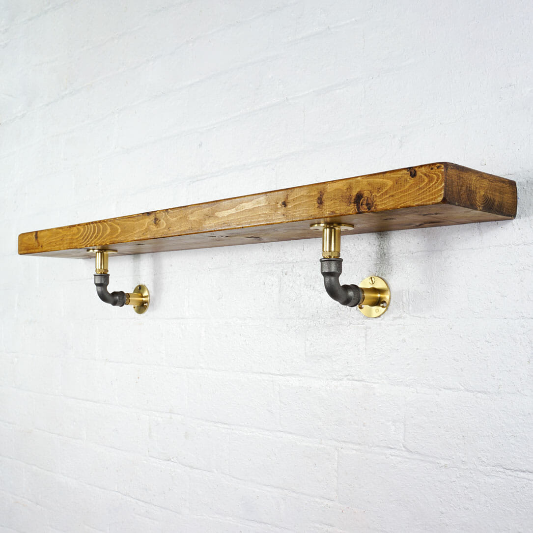 Brass industrial pipe shelf brackets with raw steel elbows with reclaimed wooden shelf